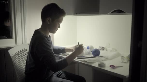 Adolescente menino pintura globo — Vídeo de Stock