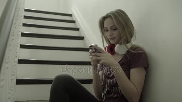 Teenager girl on staircase with smart phone — Stock Video