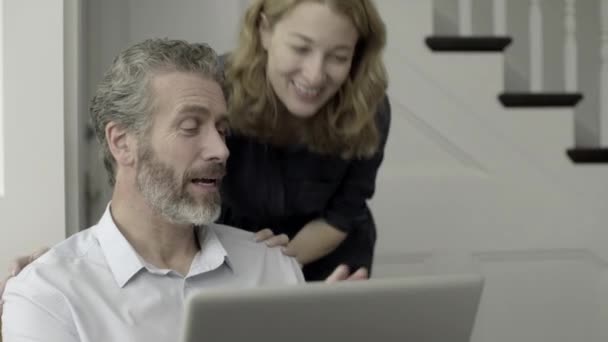 Взрослая пара, работающая на ноутбуке — стоковое видео