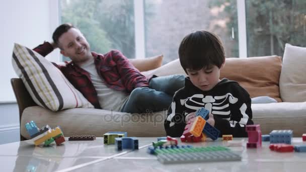 Father watching son playing with blocks — Stock Video