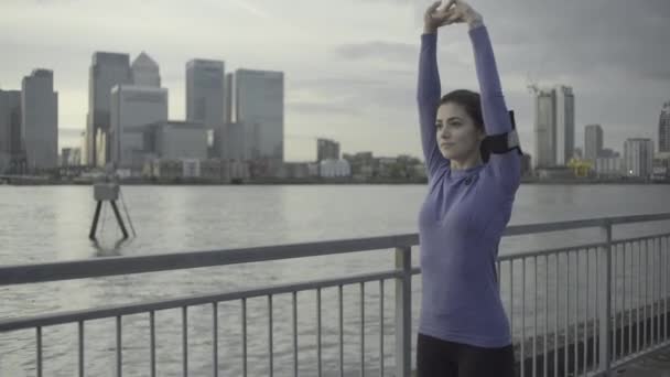 Vrouwelijke atleet, die zich uitstrekt door de rivier de Theems — Stockvideo