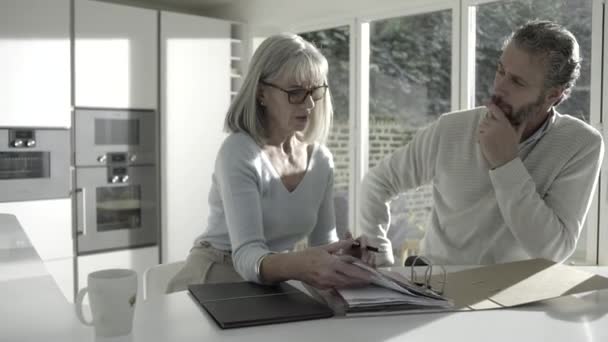 Male with senior female looking at personal finance — Stock Video