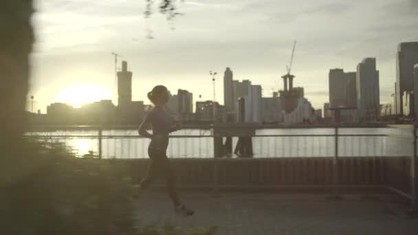 Female runner jogging by river Thames — Stock Video