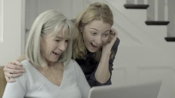 Старша жінка дивиться на ноутбук з дочкою — стокове відео