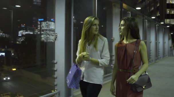 Amigos femininos andando com sacos de compras — Vídeo de Stock
