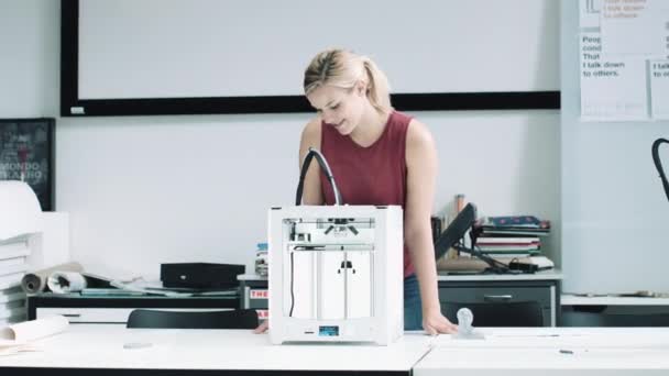 Женщина-дизайнер смотрит на трехмерный печатный объект — стоковое видео