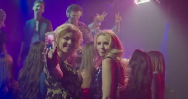 Cep telefonu ile kendini fotoğraf gece kulübünde müzik tadını çıkarırken alarak arkadaşlar