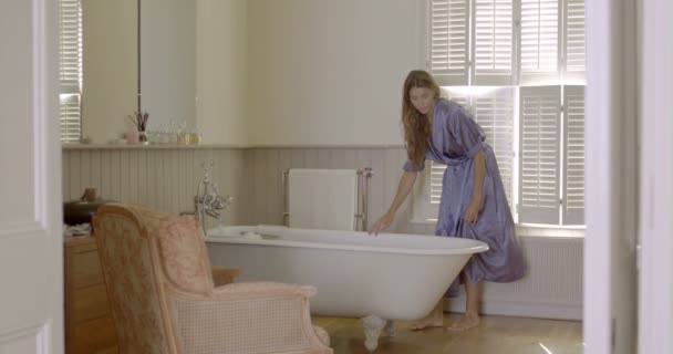 Kvinna sitter på kanten av badkaret — Stockvideo