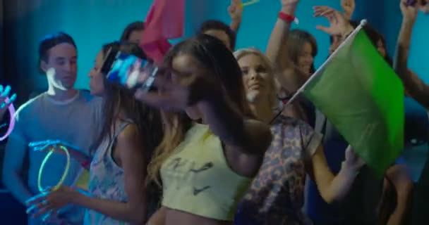 Женщина фотографирует себя во время танцев с друзьями в ночном клубе — стоковое видео