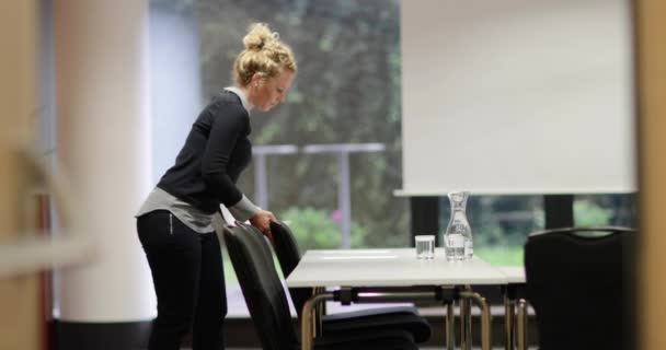 Femme d'affaires préparant la salle de réunion 