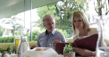 Bir restoranda bir menüyü okuyan arkadaşları