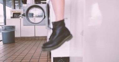 Kadın oturma bekleyen laundrette içinde çizme yakın çekim
