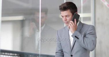 Yansıma seyir ve bir ofiste smartphone kullanarak iş adamı