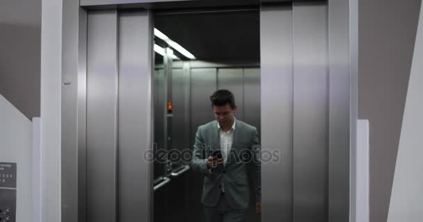 Empresario Saliendo Del Ascensor Una Oficina Con Smartphone — Vídeos de Stock