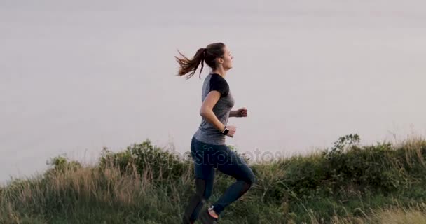 活跃的年轻成年女性在悬崖上海上奔跑 — 图库视频影像