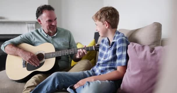 Padre Mostrando Hijo Que Puede Tocar Guitarra — Vídeos de Stock