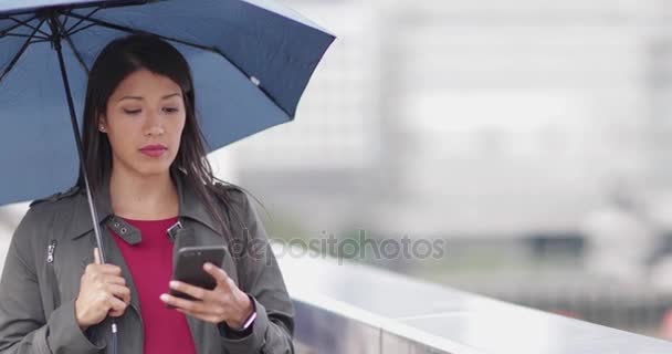 Geschäftsfrau Der Stadt Hält Regenschirm Und Schaut Aufs Smartphone — Stockvideo