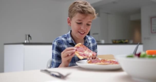 Jongen Nemen Van Een Hap Uit Een Plak Van Pizza — Stockvideo