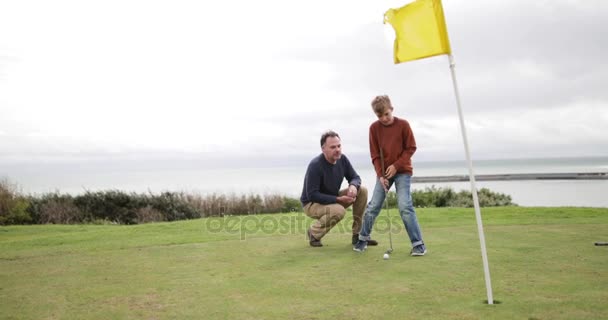 Vater Beobachtet Sohn Beim Golfspielen — Stockvideo