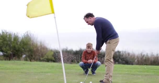 Filho Assistindo Pai Jogar Golfe — Vídeo de Stock