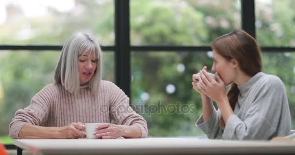 Madre e hija alcanzando a través del café — Vídeos de Stock