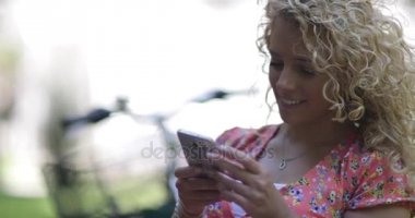 Açık havada Smartphone kullanarak genç yetişkin kadın