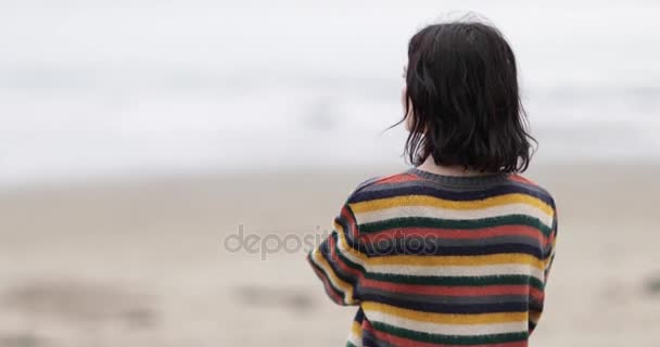 Молодая женщина смотрит на море — стоковое видео