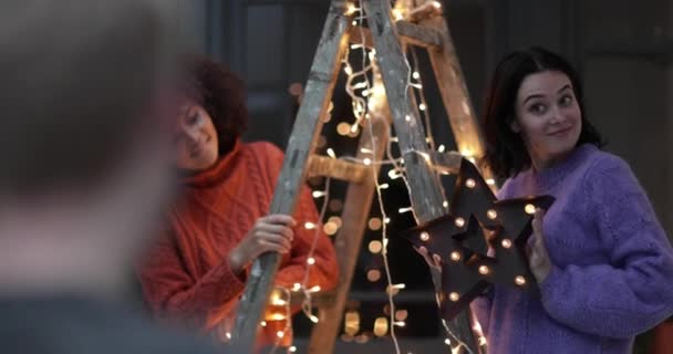 Amigos decorando un árbol de navidad alternativo — Vídeo de stock