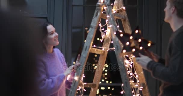 Casal decorando uma árvore de Natal alternativa — Vídeo de Stock