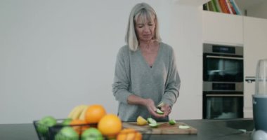 Kıdemli kadın meyve kesiyor. 