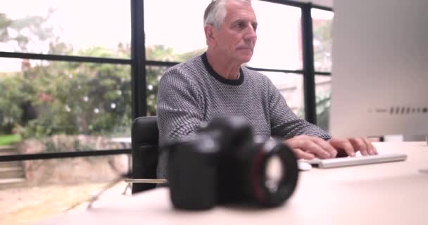 Старший чоловік завантажує фотографії — стокове відео