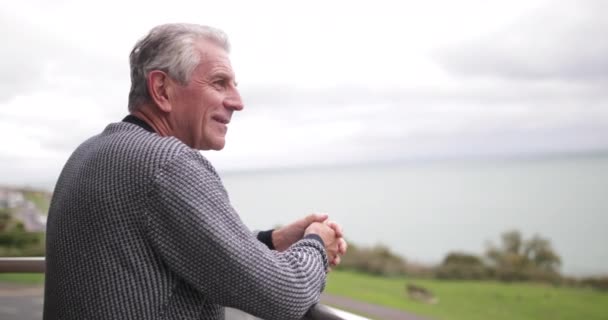 Старший человек наслаждается видом на море — стоковое видео