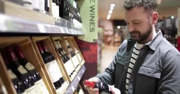 Hombre eligiendo vino — Vídeos de Stock