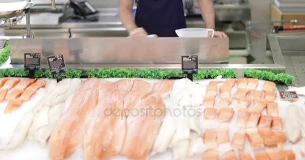 Fishmonger at counter in store — Stock Video