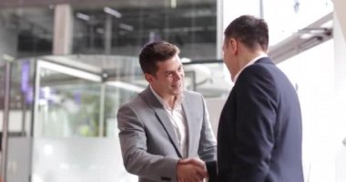 Bir şirket ofisi tokalaşırken işadamları