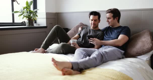 Joven Pareja Masculina Mirando Juntos Teléfono Inteligente — Vídeos de Stock