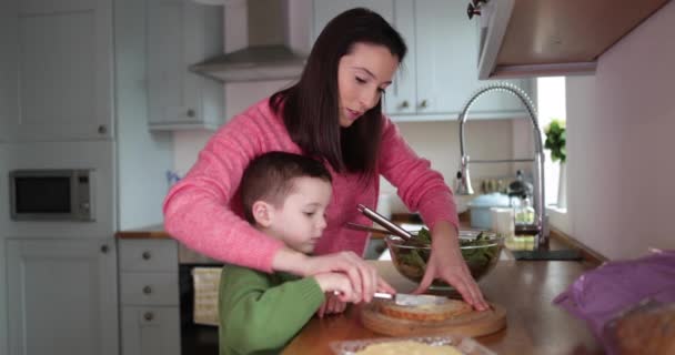 Chico Haciendo Sándwich Con Madre Ayudando — Vídeo de stock