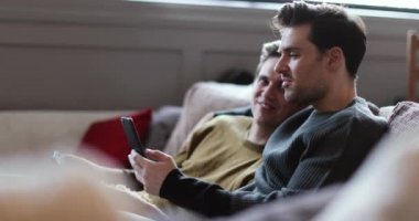 Genç erkek çift eğlence akış kanepede rahatlatıcı