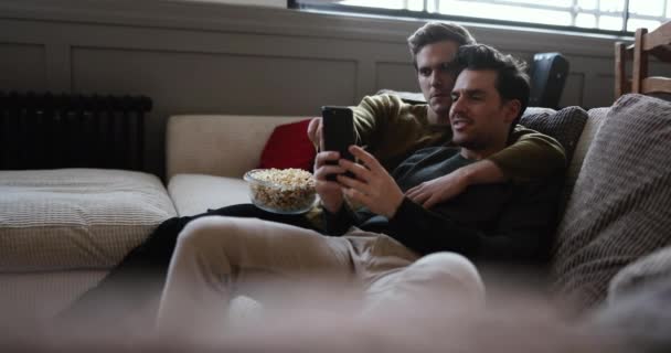Jeune Couple Masculin Relaxant Sur Canapé Streaming Divertissement — Video