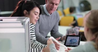 Öğrenciler öğretmen ile 3D yazıcı tartışıyor