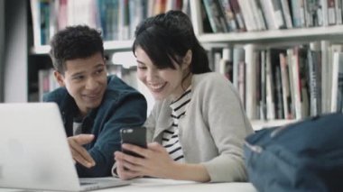 Kitaplıkta Smartphone kullanan öğrenciler
