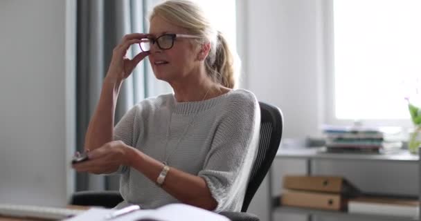 デスクトップ コンピューターとスマート フォンに取り組んでいる成熟したビジネス女性 — ストック動画