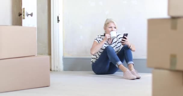 Mature Female Using Smartphone Moving Boxes — Stock Video