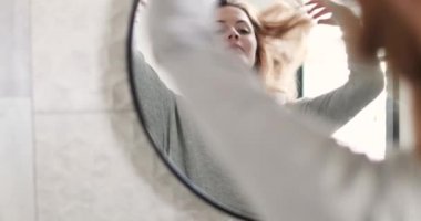 Genç yetişkin kadın banyo aynaya bakmak yansıma