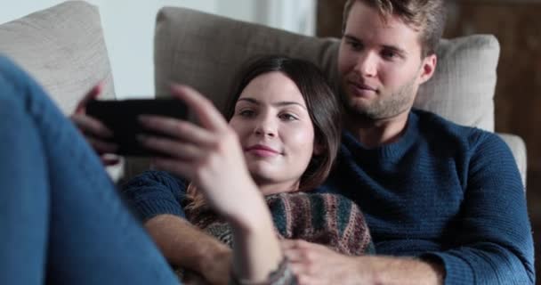 Paar Ontspannen Sofa Thuis Kijken Naar Video Smartphone — Stockvideo