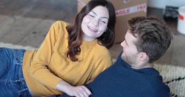 Yeni ev halı üzerinde uzanmış Çift