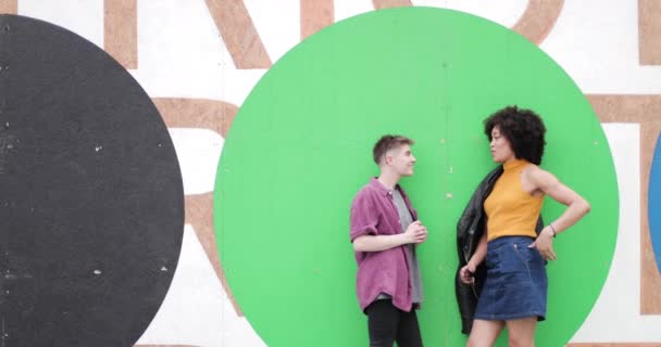 Milenyum kuşağı renkli duvarın yanında duruyor — Stok video