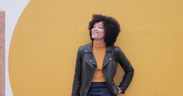 Retrato de jóvenes adultos afroamericanos que se apoyan en un muro amarillo brillante riendo — Vídeos de Stock