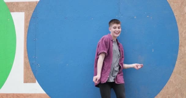 Portrait of young adult dancing by bright blue wall — Stock Video