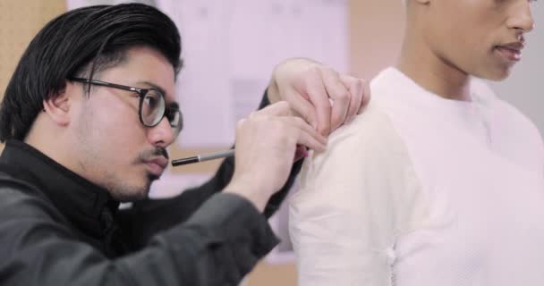 Дизайнер моди, який працює над дизайном з моделлю — стокове відео
